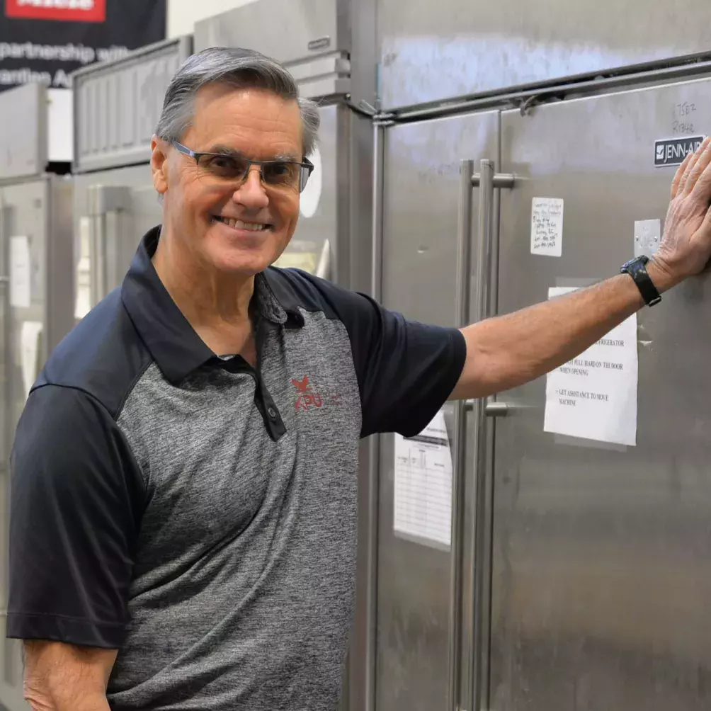 Dave Fengstad smiling at camera and leaning on the fridge at KPU Tech